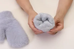 Detail view of plush grey winter mittens showing soft thick interior lining and warm material.