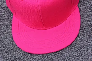 Detaillierte Nahaufnahme der hellrosa Flat Brim Mütze mit feinen Nähten und Stofftextur.