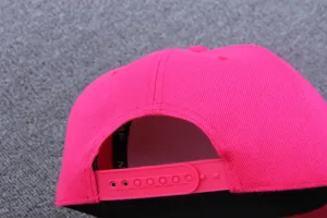 Detaillierte Rückansicht einer einfarbigen hellrosa Snapback Baseballkappe mit verstellbarem Riemen.