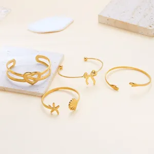 Ensemble de bracelets jonc ouverts en acier inoxydable doré avec motifs de cœur et nœud.