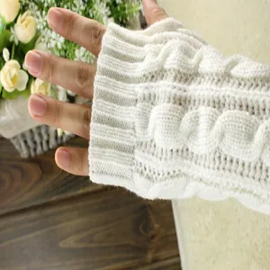 Close-up detail of white cable-knit fingerless arm warmer glove, soft wool texture.
