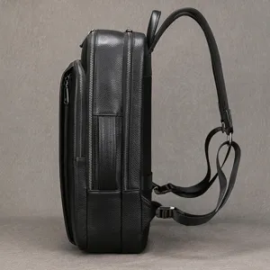 Side detail of black leather business backpack, showing dual compartments and robust straps.