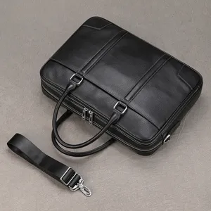 Detailed view of black genuine leather business briefcase with double handles and strap.