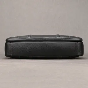 Detailed view of the black leather briefcase bottom, fine stitching and durable structure.