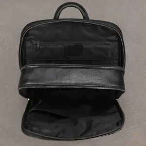 Detailed view of the black genuine leather business laptop backpack with multiple zipper compartments.