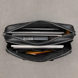 Detailed view of the multi-compartment black leather briefcase interior showcasing laptop capacity.