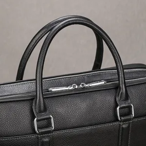 Close-up detail of men's leather briefcase, showing premium leather texture and hardware.