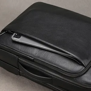Genuine leather business backpack detail shot showing premium pebble texture and metal zippers.