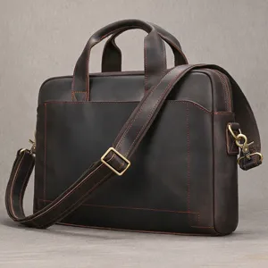 Primo piano di una ventiquattrore in vera pelle con cuciture robuste e accessori metallici resistenti.