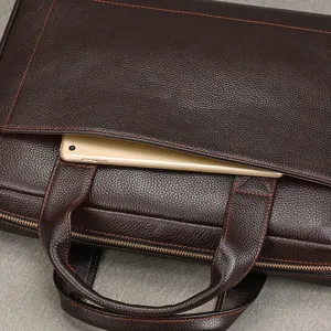 Dettaglio borsa ventiquattrore in vera pelle marrone scuro, pelle bovina con cuciture arancioni.