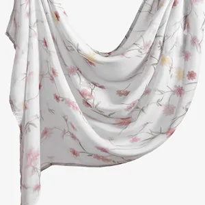 Close-up of a white floral printed rayon scarf, showing delicate pink flowers and soft texture.