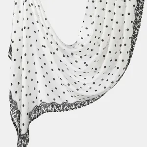 Detailed view of the white long scarf featuring classic black polka dots and an elegant lace border design.