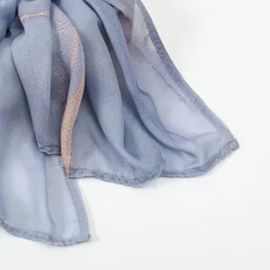 Close-up detail of blue printed women scarf fabric edge, elegant pattern and neat stitching.