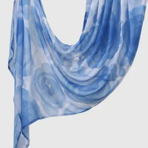 Blue watercolor floral print scarf detail showing soft fabric texture and graceful drape effect.