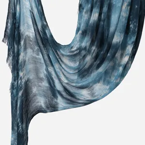 Detailed view of women blue tie-dye crinkle scarf, lightweight draped shawl and long headscarf.