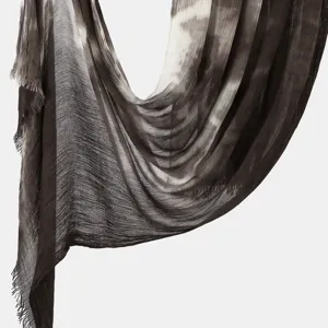 Close-up detail of lightweight crinkled tie-dye scarf showcasing soft texture and fine fringe.