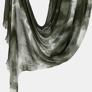 Close-up detail of women's tie-dye crinkle scarf, lightweight green draped shawl fabric.