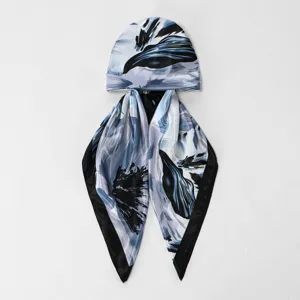 Satin headscarf cap detail showing smooth fabric, elegant blue abstract print and long ribbon tails.