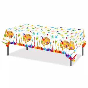 Detailed view of the colorful art painting party tablecloth with paint splatters and brushes.
