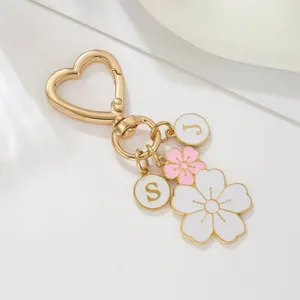 Goldener Herz-Schlüsselanhänger mit Buchstaben und schönen Emaille-Blumenanhängern.