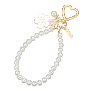 Perlenperlen Schlüsselanhänger mit süßen Emaille Kirschblüten Blumen und goldener Herzschnalle.
