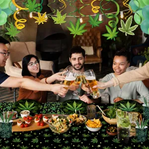 Escena detallada de fiesta alegre con mantel de hojas de cannabis y vajilla desechable.