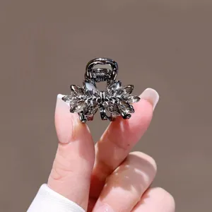 Gros plan detail de la petite pince a cheveux cristal noir, design noeud brillant.