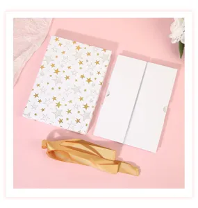Detailed view of gold star gift box with folding white inner box and elegant ribbon.