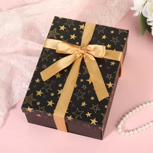 Black gold star gift box with ribbon bow, elegant empty packaging for birthday holiday parties.