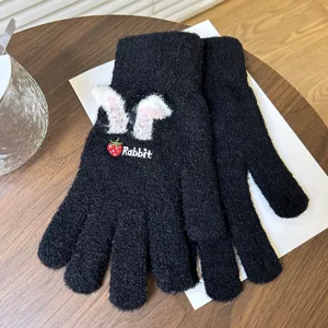 Vue détaillée de gants d'hiver en tricot noir avec de jolies oreilles de lapin et une broderie.