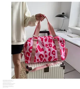 Vue détaillée du sac de voyage rose imprimé léopard avec des bretelles solides et design.