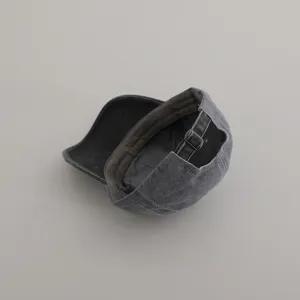 Detail view of the vintage washed grey baseball cap showing adjustable metal buckle strap.
