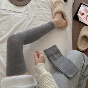 Gedetailleerd overzicht grijze gebreide beenwarmers over de knie voor dames, winter sokken.