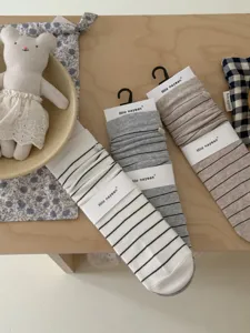 Vue détaillée de chaussettes rayées japonaises avec boutons coquillage sur table.