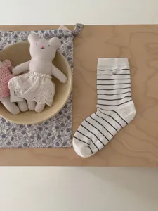 Gros plan de chaussettes en coton pour femmes style japonais avec rayures et bouton.
