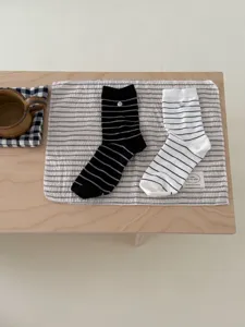 Vue détaillée de chaussettes mi-hautes rayées en coton style japonais avec bouton coquillage.