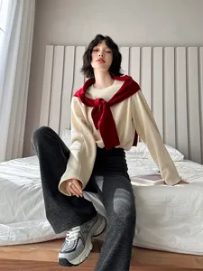 Vue détaillée de pull décontracté et pantalon évasé portés par un mannequin en chambre.