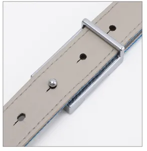 Close-up view of women leather belt with metal buckle and denim backing, vintage style detail.