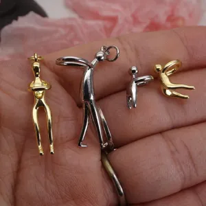 Detail shot of copper human figure pendant, metal abstract art body charm for DIY jewelry crafting.