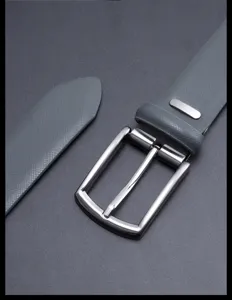 Leather belt detail shot featuring textured grey split cowhide leather and a polished metal pin buckle.