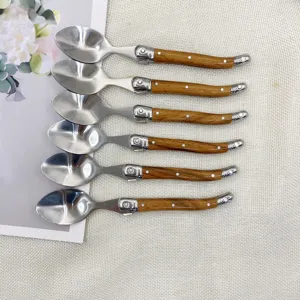Detailansicht von Bestecklöffeln aus Edelstahl mit eleganter Holzmaserung und polierter Laffe.