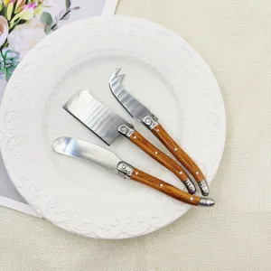 Edelstahl Butter Käse Messer Detail, Holzmaserung Griff, elegante Tischdekoration Nahaufnahme.