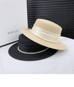 Flat top straw hat detail, summer wide brim sun hat decorated with elegant pearls and ribbons.