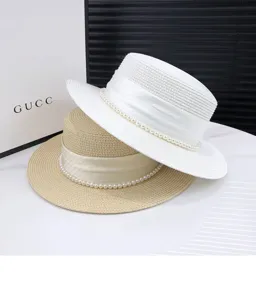 Summer pearl straw hat for women, wide brim sun hat, stylish beach travel headwear.