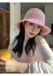 Pink straw bucket hat detail view, featuring wide brim and sweet design for summer.