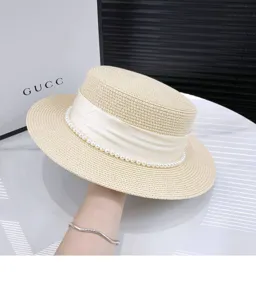 Summer flat top straw hat with pearl decor and wide brim, elegant vintage sun protection beach hat.