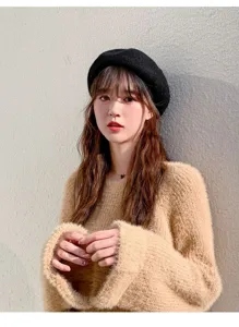 Classic black beret paired with a cozy fuzzy sweater, perfect for autumn and winter style.