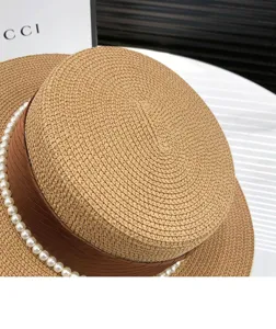 Women flat top straw hat with brown ribbon and pearl decor, summer sun protection beach cap.