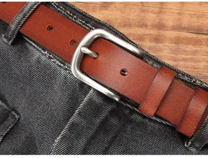 Primo piano dettagliato di cintura da donna in pelle marrone con fibbia argentata sui jeans.