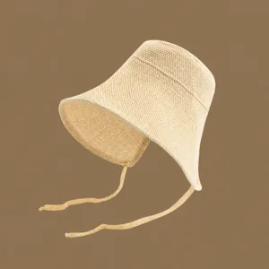 Closeup of the summer woven straw sun hat, showcasing delicate handmade texture and wide brim.